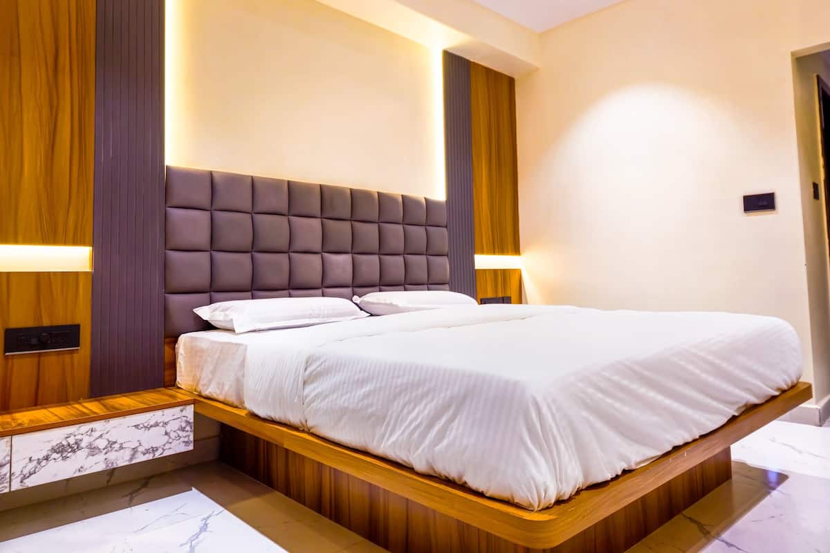 Ein modernes Schlafzimmer mit einem großen Bett, einem Holzkopfende und integrierten Nachttischen.