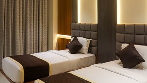 A hotel room with two beds, a ceiling fan, and recessed lighting. - Hotel Lemon Park (Visakhapatnam)