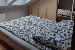 Une chambre à coucher avec un lit, une armoire et une fenêtre.
