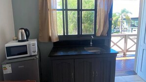 A compact kitchen with a microwave, a kettle, and a sink. - Mirador del Dayman  (Termas del Dayman)