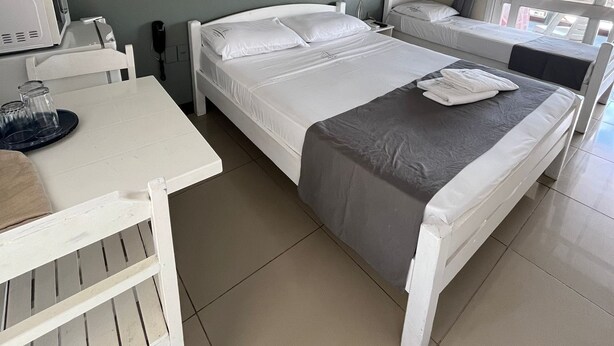 A bedroom with a bed, a desk, a chair, a lamp, and a window. - Mirador del Dayman  (Termas del Dayman)