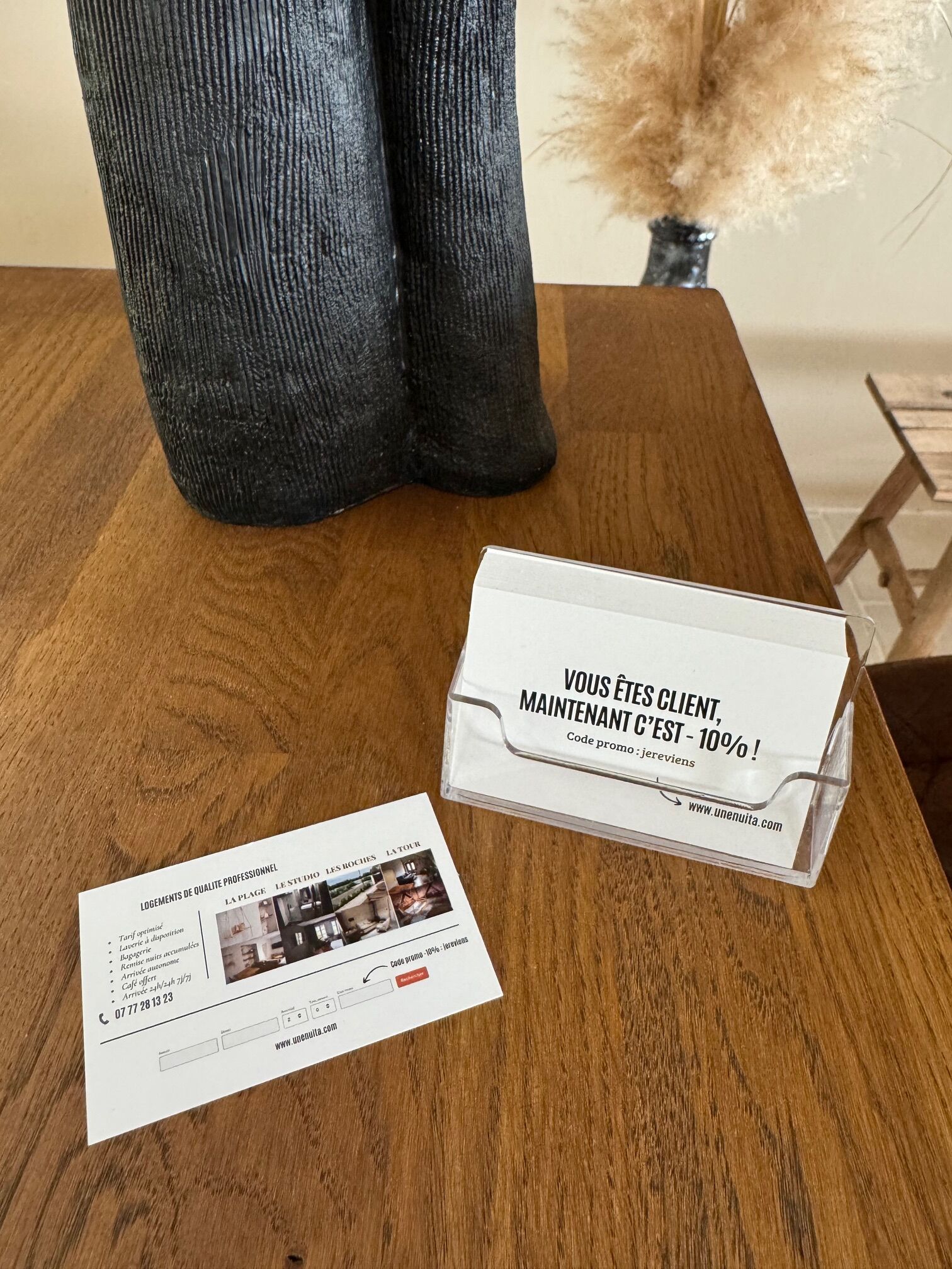 Een houten tafel met een brochure en een promotiekaart.