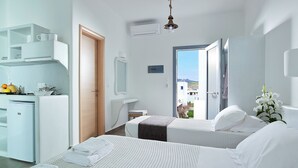 Een moderne hotelkamer met twee bedden, een kitchenette, een badkamer en een balkon met uitzicht.