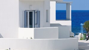 Een modern wit gebouw met een balkon, een deur en een raam.