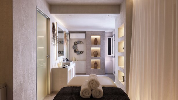 Een moderne hotelkamer met een bed, een badkamer en een klein zithoekje.