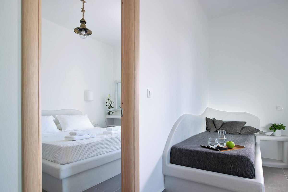 Une chambre à coucher moderne avec un lit, une table de chevet et un miroir.