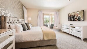 A bedroom with a large bed, a dresser, a television, and a window with curtains. - Luxury Private Pool, Spa, Game Room - 15 min Disney! Free Pool Heat + BBQ (Kissimmee)