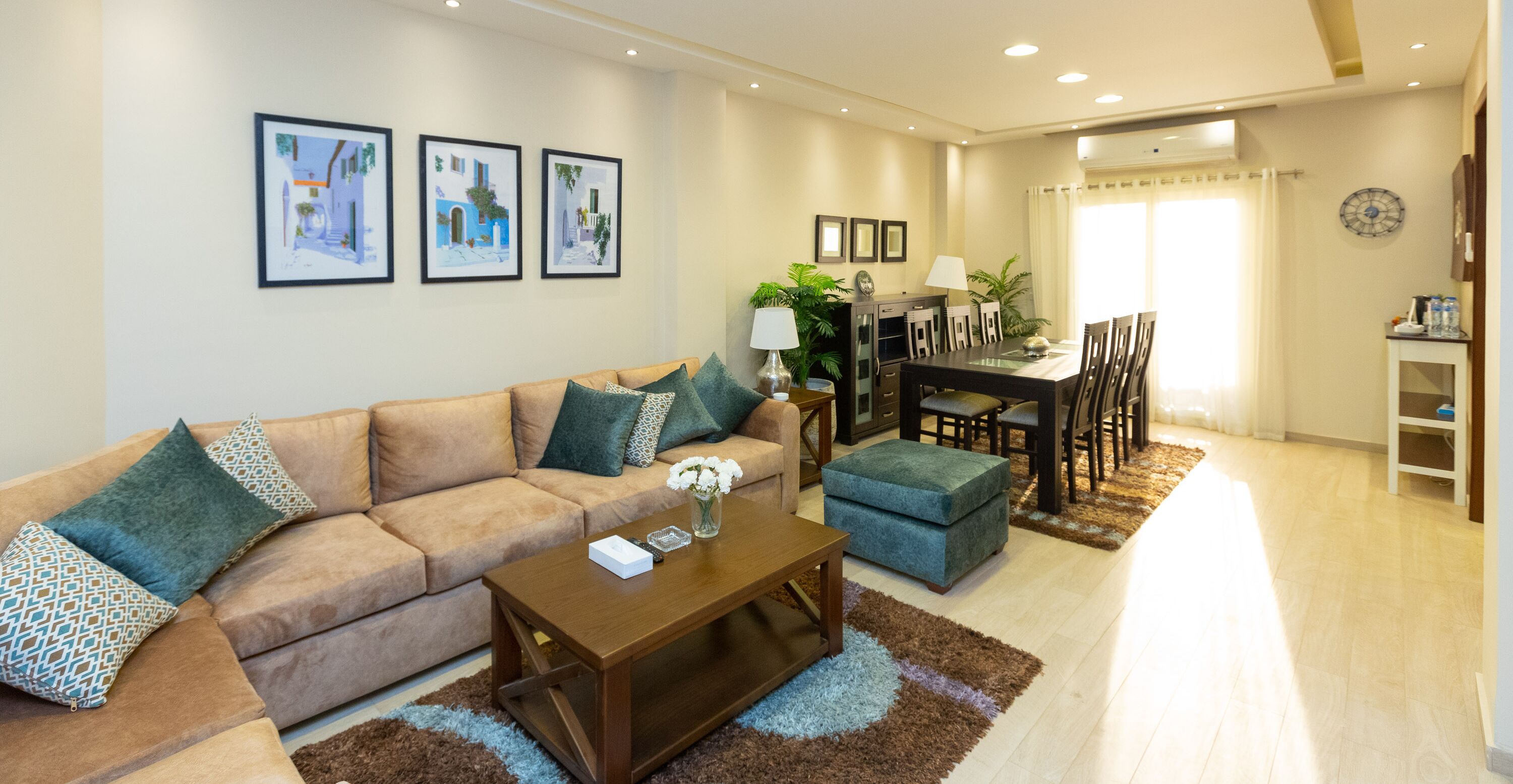 Sala de estar com sofá, mesa de centro e área de jantar com cadeiras e mesa.