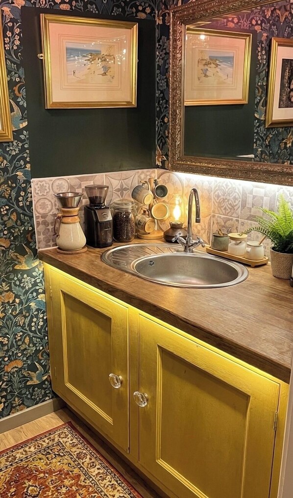 A kitchen with a double sink, decorative tiles, and a mirror above the sink.