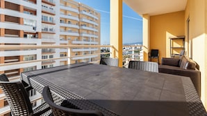 A balcony with a dining table, chairs, and a sofa. - Rorippa Apartment, Portimao, Algarve (Portimão)