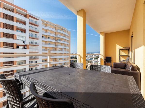 A balcony with a dining table, chairs, and a sofa. - Apartment in Rorippa, Portimão, Algarve (Portimão)