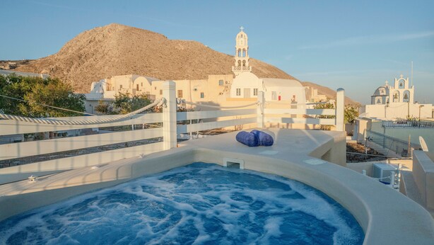 A hot spring area with a view of a mountain and a church in the background.