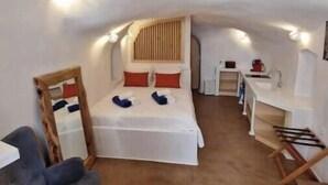 Una habitación pequeña y bien iluminada con una cama, un escritorio y una silla.