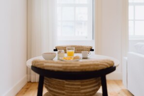 A breakfast table with a bowl, a glass of orange juice, a cup, and a plate of food. - Feel Porto Cl Rigos Charm Flat 1 2 (Porto)