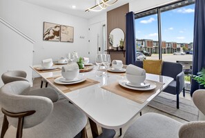 A modern dining room with a large table set for six, surrounded by contemporary chairs. - 8761 ZD - 3 BD The Hub Paradise Cozy Place (Four Corners)
