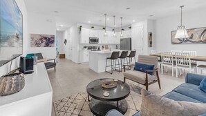 A modern apartment with a kitchen, dining area, and living room.