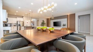 A modern kitchen with white cabinets, a stainless steel refrigerator, and a built-in oven.