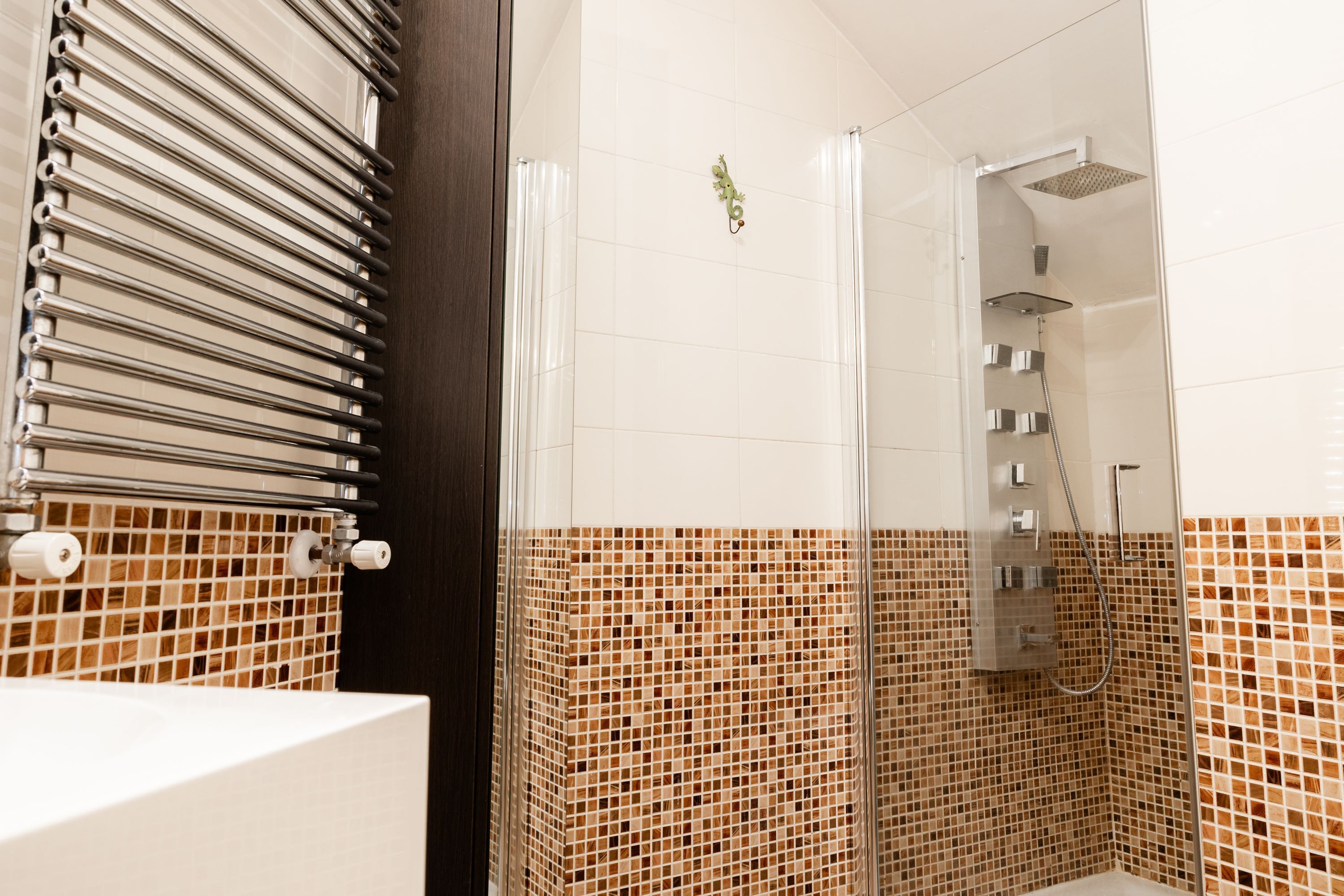 A bathroom with a shower, tiled walls, and a wooden door.