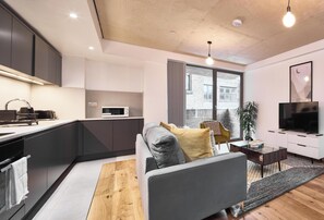 Un apartamento moderno con cocina, sala de estar y un ventanal grande.