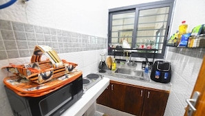 Una cocina pequeña con microondas, pileta y ventana.