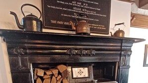 A vintage pizza oven with a menu above it listing various pizza types. - George Hotel Hayfield (High Peak)
