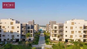 A modern residential complex with multiple white buildings, a central pathway, and landscaped areas. - Prime Select Mall of Arabia (6th of October City)