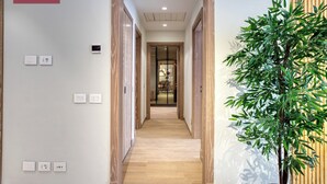 A hallway with wooden flooring, a potted plant, and a sign reading "PRIME SELECT". - Prime Select Mall of Arabia (6th of October City)