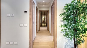 A hallway with wooden flooring, a potted plant, and a sign reading "PRIME SELECT". - Prime Select Mall of Arabia (6th of October City)
