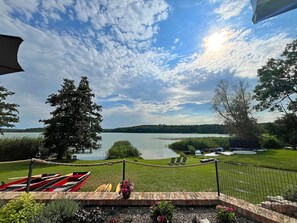 A lakeside view with boats, a grassy area, and a fence. - Holiday Apartment With Private Lake Access and Jetty (Warin)