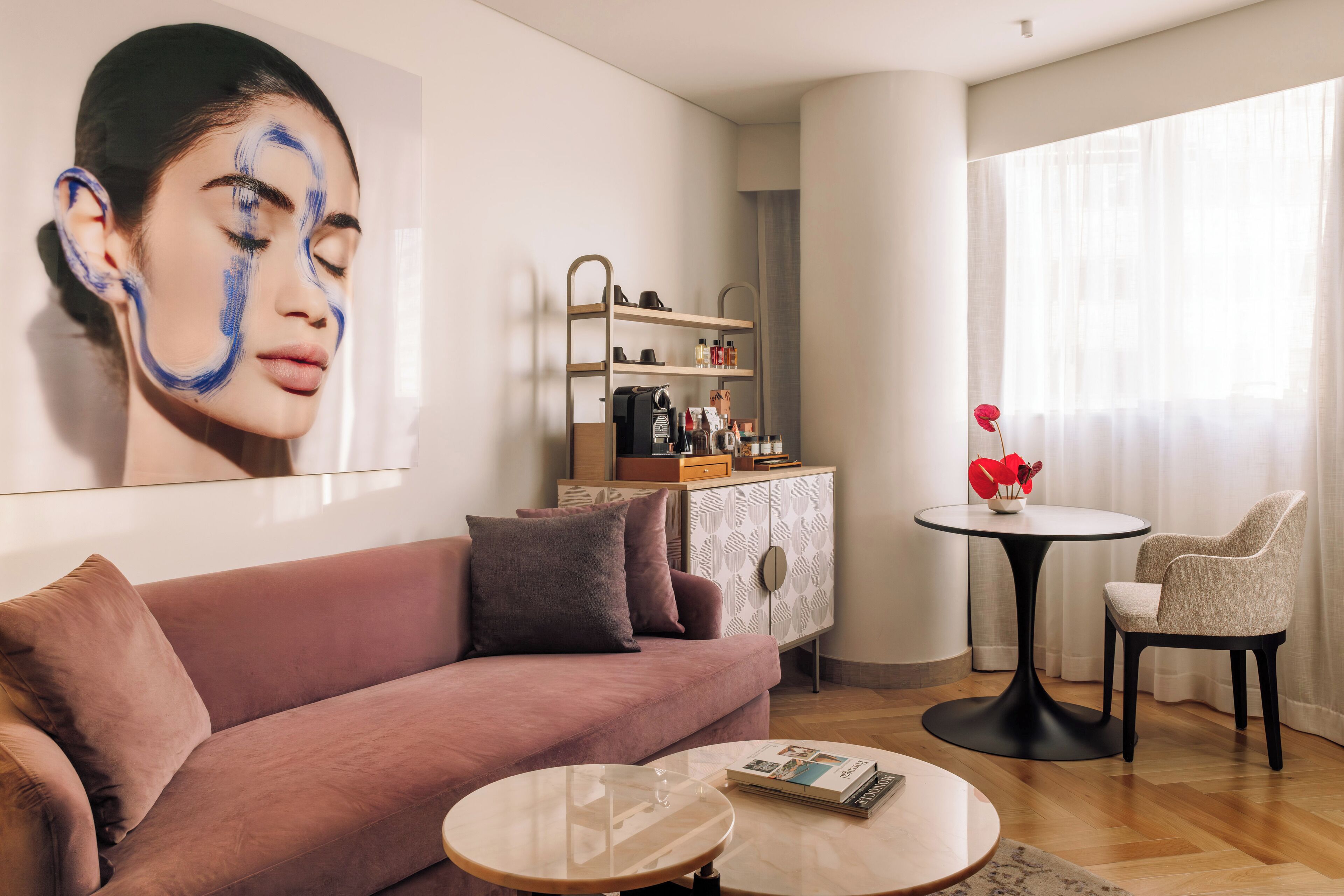 A living room with a sofa, a coffee table, a cabinet with shelves, and a chair.