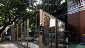 Ein modernes Gebäude mit großen Glasfenstern und einem Metallgitter.
