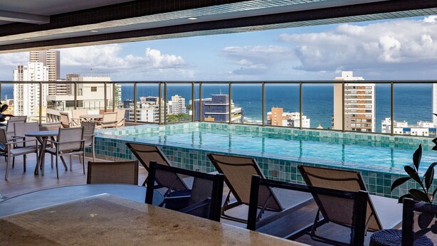 A rooftop pool area with a view of the city skyline and the ocean. - 2 Bedroom Apartment with Sea View Rooftop (Salvador)