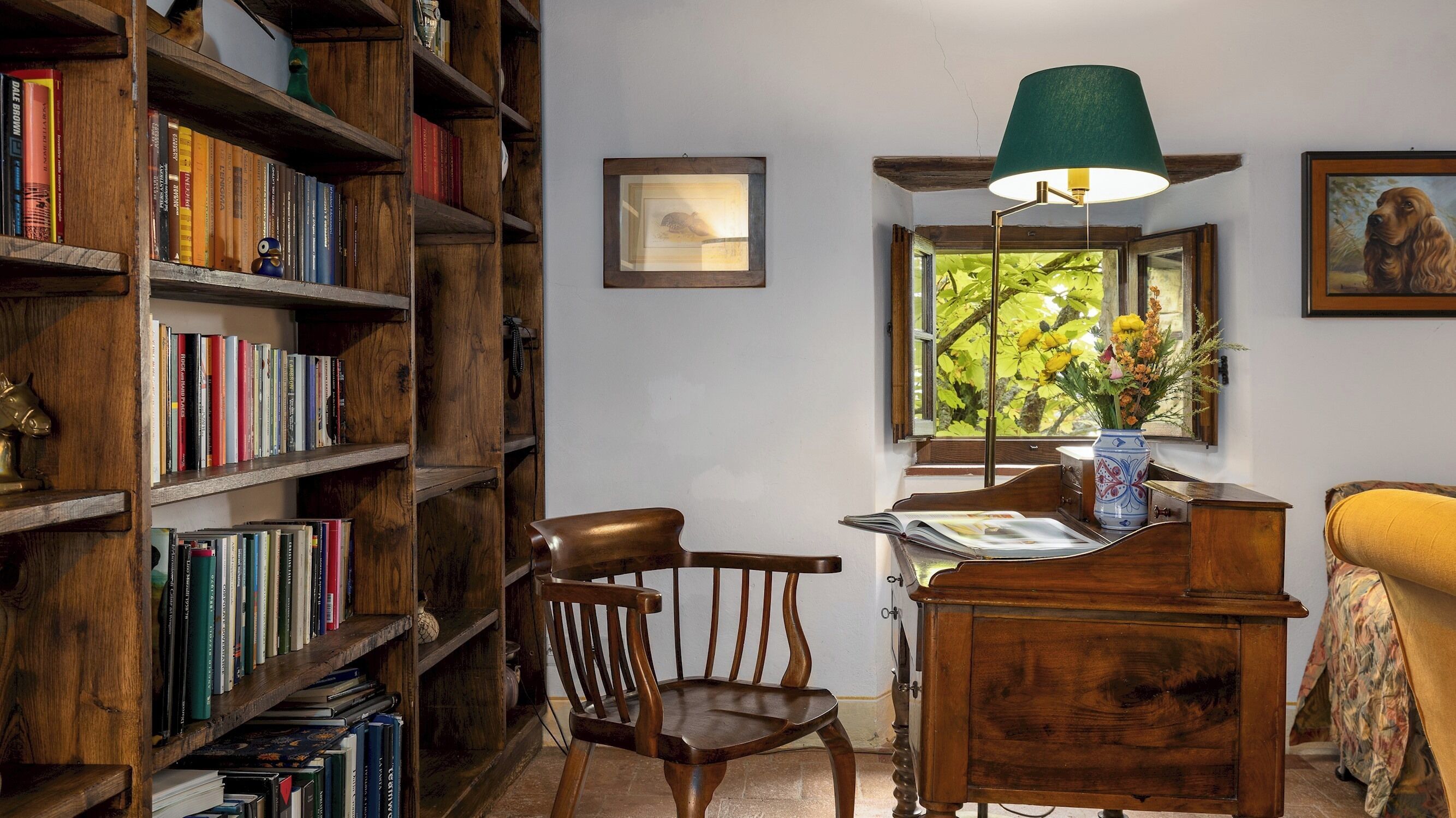 Un coin lecture confortable avec un bureau en bois, une chaise et une bibliothèque remplie de livres.