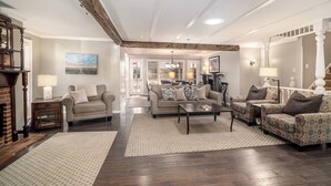 A spacious living room with a fireplace, a large sofa set, and a patterned rug.