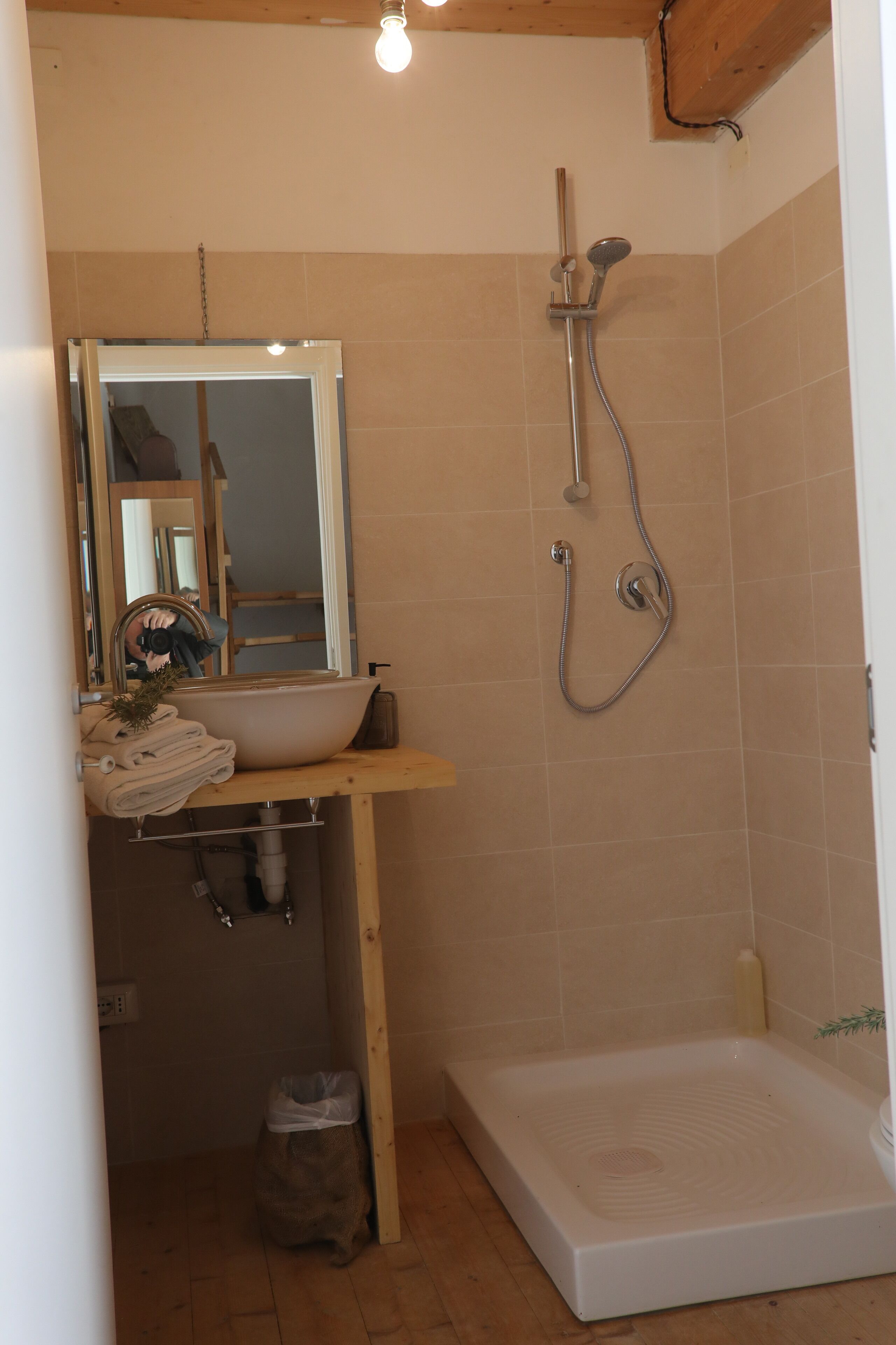 A bathroom with a sink, mirror, and shower.