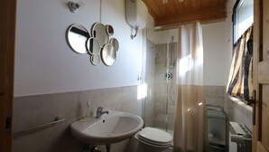 Ein Badezimmer mit Waschbecken, Toilette und einer Duschkabine.