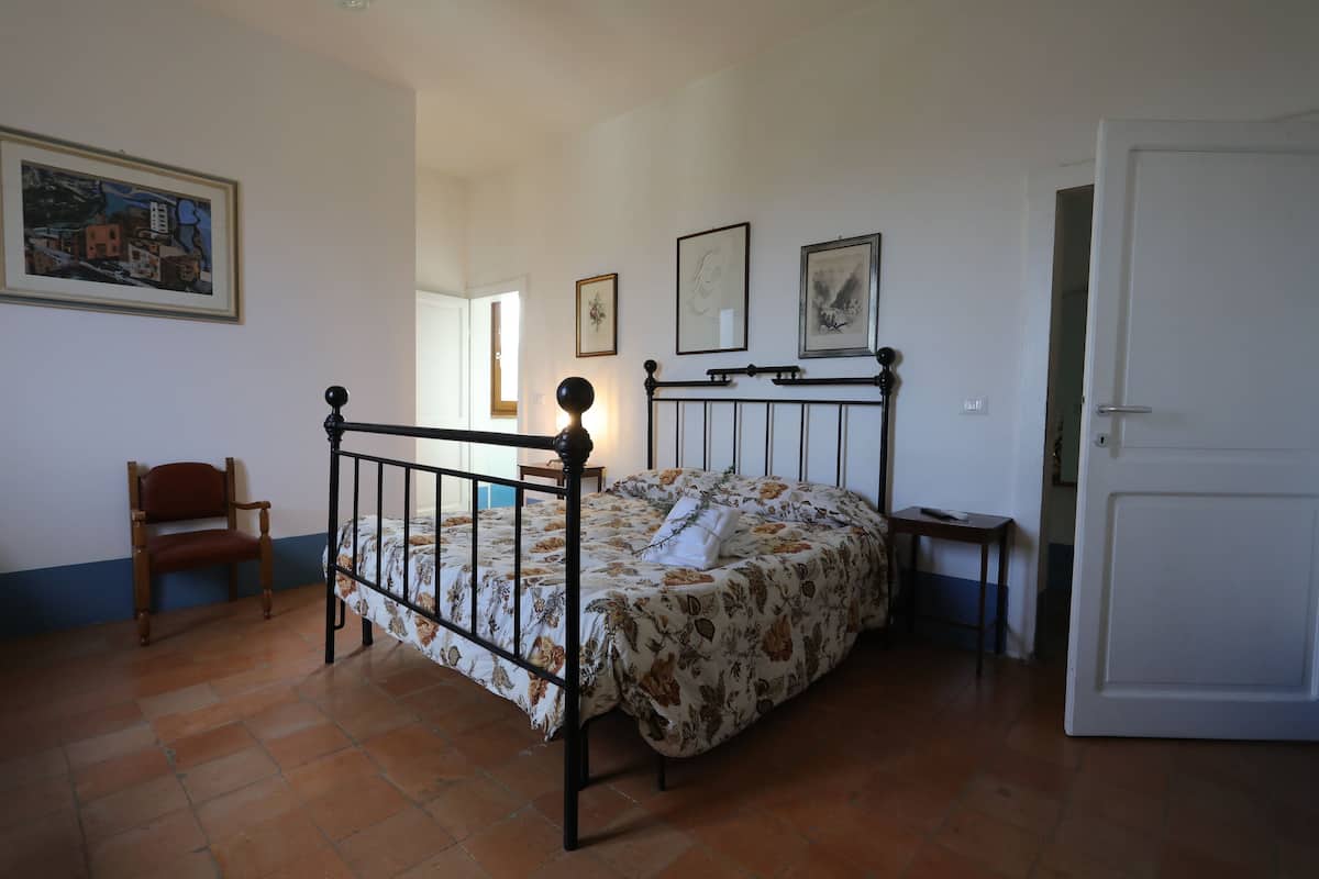 A bedroom with a bed, a chair, and a door.