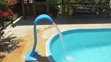 A swimming pool with a blue water feature and a tiled deck.