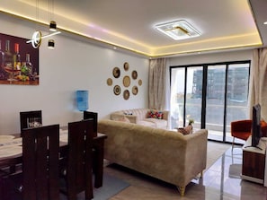Family Apartment, Balcony, City View | Living area | 34-inch Smart TV with digital channels