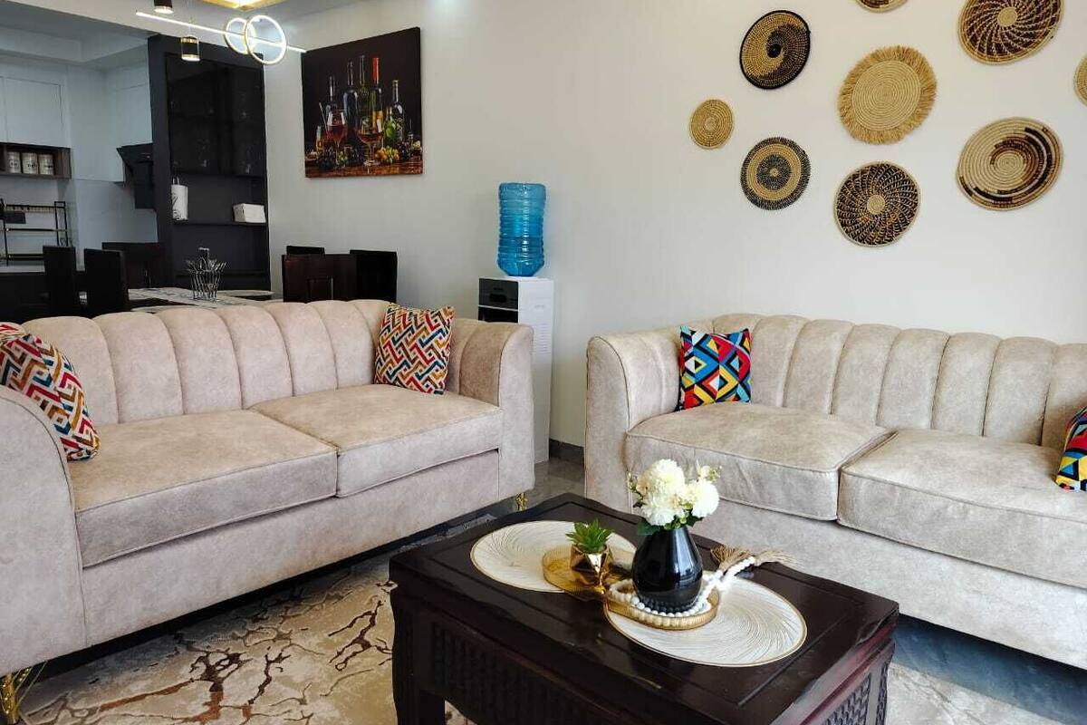 A living room with two sofas, a coffee table, and decorative wall art.