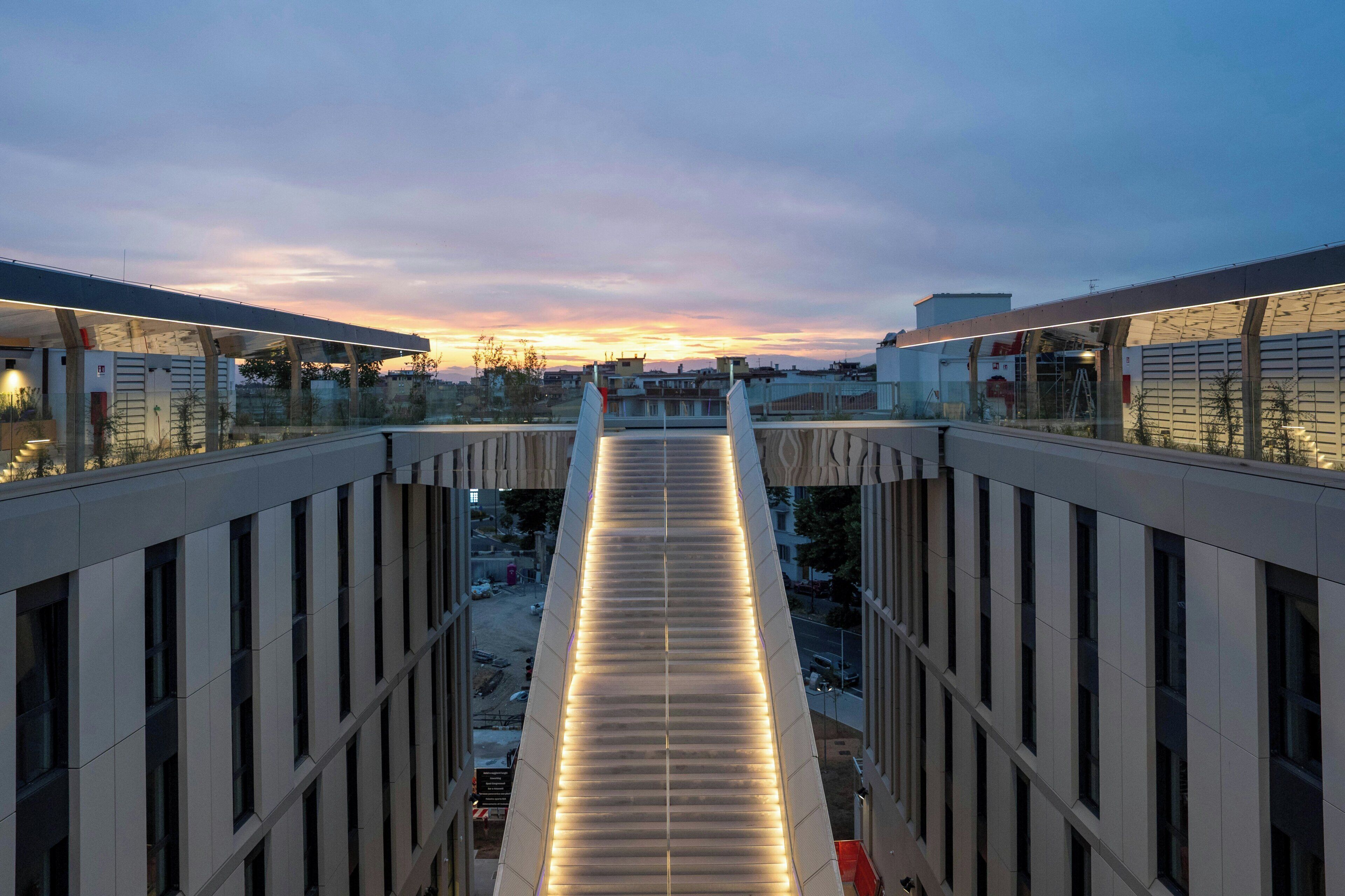 Un bâtiment moderne doté d’une allée centrale, de grandes fenêtres et d’un toit plat.