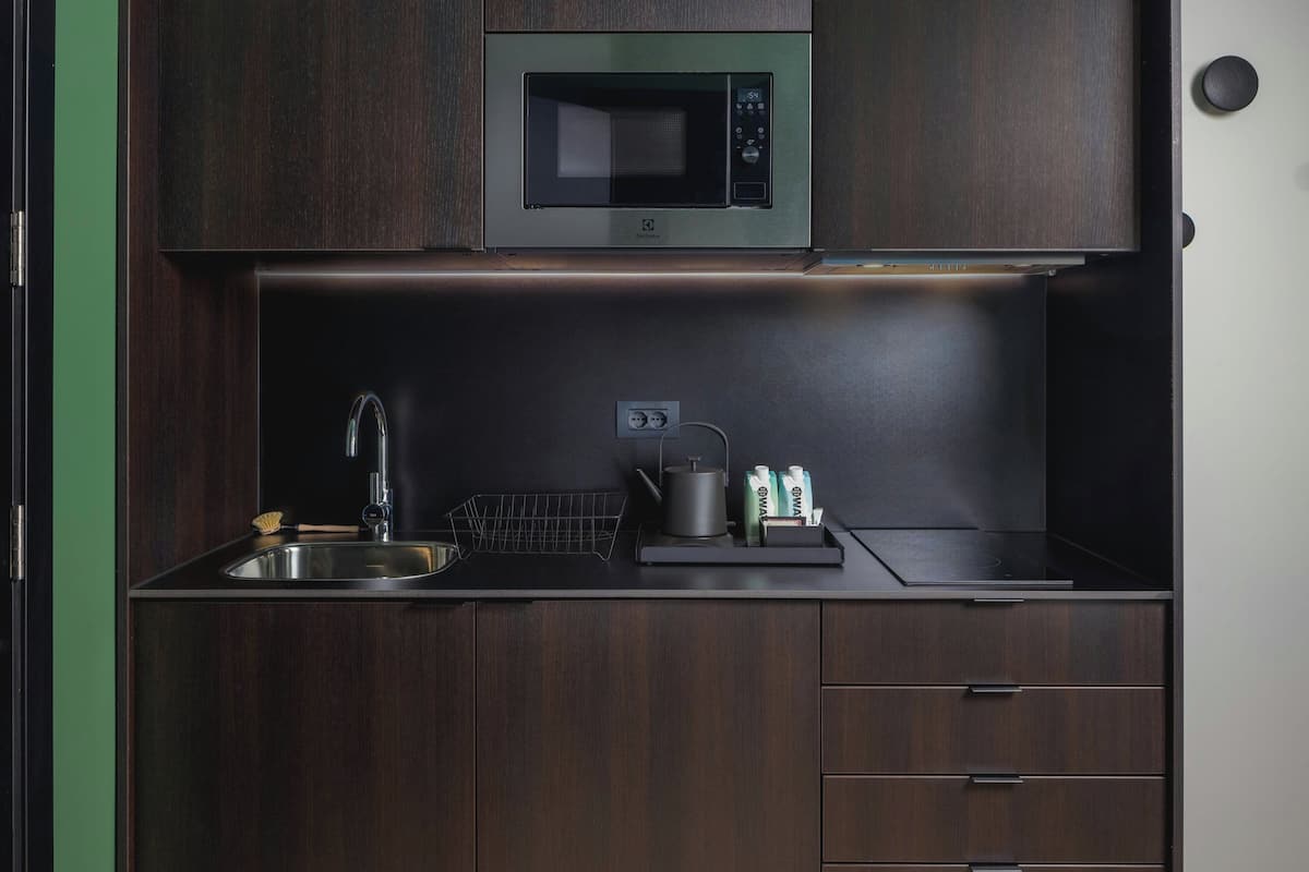 A compact kitchen with a built-in microwave, a sink, and a small countertop area.