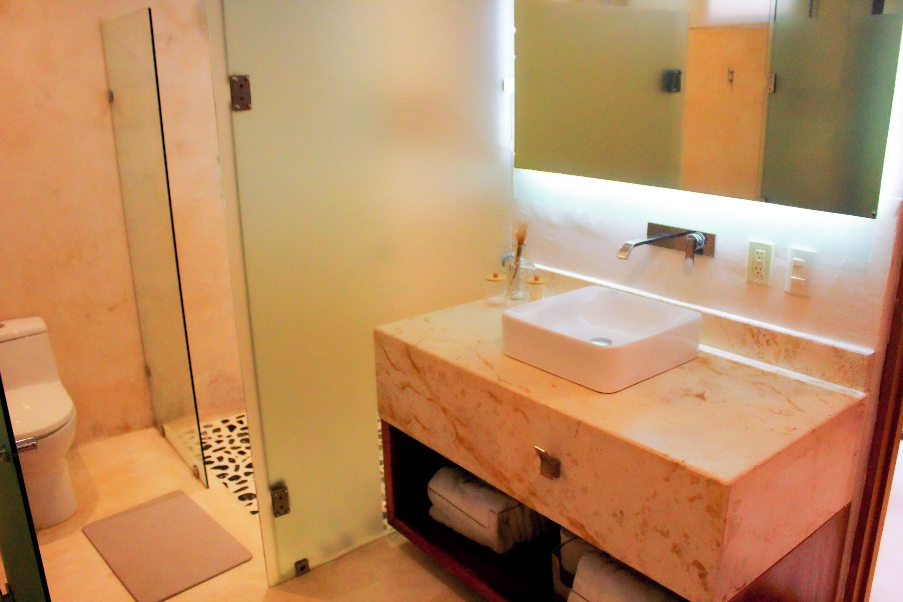 A bathroom with a white sink, a mirror, and a toilet.