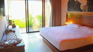 A bedroom with a large bed, a bedside table with a lamp, and a view of greenery through a sliding door. - Lipsos Retreat Concierge Villa (Ixil)