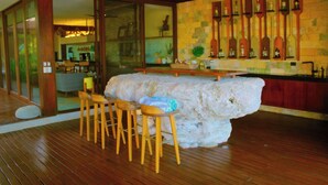 A bar area with a large ice sculpture centerpiece, wooden stools, and a tiled wall with bottles. - Lipsos Retreat Concierge Villa (Ixil)