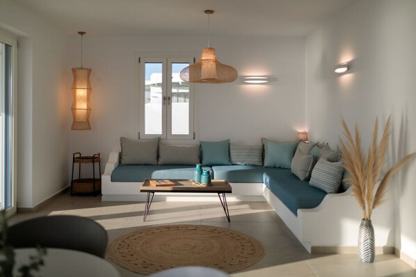 Ein modernes Wohnzimmer mit einem Ecksofa, einem Couchtisch und einer Hängeleuchte.