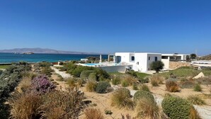 A modern house with a pool, surrounded by a landscaped garden and a view of the sea. - Villa Salt Mikri Vigla Naxos (Mikri Vigla)