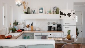 Eine moderne Küche mit Kochinsel, Kaffeemaschine und Kühlschrank.