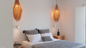 Ein Schlafzimmer mit einem Bett, Nachttischen und Pendelleuchten.