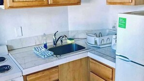 A compact kitchen with wooden cabinets, a sink, a stove, and a refrigerator. - Two double bed studio with full kitchen on 2nd floor . (Pompano Beach)